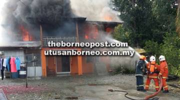 BERTUNGKUS-LUMUS: Anggota bomba berusaha memadam kebakaran membabitkan tingkat atas rumah tersebut.