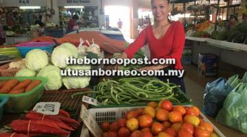 SUSUN: Joen menyusun sayur yang dijual di Pasar Komuniti Stutong, Kuching, semalam.