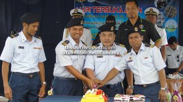 SIMBOLIK: Md Fauzi (depan, dua kanan) memotong pulut kuning simbolik perasmian Hari Terbuka DM13 Miri sempena Hari Ulang Tahun Maritim Malaysia Ke-13 semalam.