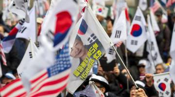 TETAP SOKONG: Penyokong Park berhimpun di luar mahkamah selepas pendakwa raya memohon hukuman penjara selama 30 tahun terhadap bekas presiden itu di Seoul, semalam. — Gambar Yonhap/Reuters