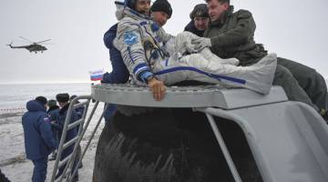 SELAMAT KEMBALI: Kru darat membantu Acaba keluar dari kapsul angkasa Soyuz MS-06 selepas ia mendarat di kawasan terpencil di luar bandar Dzhezkazgan di tengah Kazakhstan, semalam. — Gambar AFP