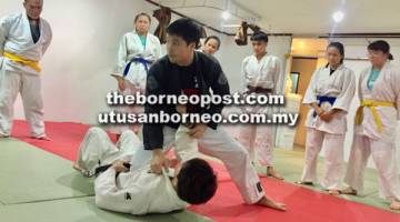 LATIHAN: Raphael (berbaju hitam) menunjukkan teknik jiujitsu kepada atlet judo Sarawak pada sesi latihan di Kuching malam kelmarin.