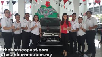 BERGAYA: Jimisar Autotrade Sdn Bhd yang diketuai oleh pengurus jualan John Lau (kiri) merakam kenangan bersama Leona (empat kanan) pada acara Mitsubishi Ultimate Drive di Sibu.