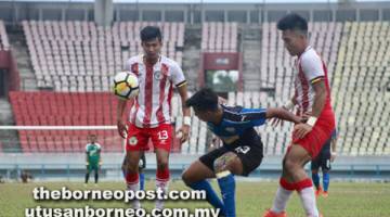 LEPASI KAWALAN: Pemain UiTM FC melepasi kawalan pertahanan Sarawak pada saingan Kumpulan B kempen Piala Presiden 2018 di Kuching semalam.