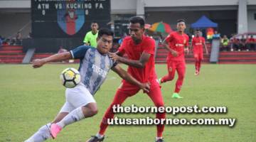 BERSAING: Pemain Kuching FA, Sufizal Ismail cuba melepasi pertahanan ATM pada perlawanan kempen Piala FAM di Kuala Lumpur kelmarin.