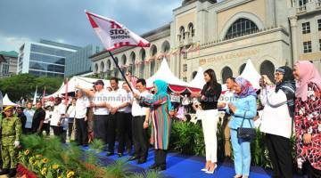 KUTIP DANA: Raja Zarith Sofiah mengibarkan bendera pada acara larian Add Hope KFC.