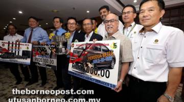 HADIAH LUMAYAN JADI REBUTAN: Sarudu (tiga kanan) bersama penaja dan kakitangan PUSAKA pada majlis penyerahan tajaan di Kuching semalam. — Gambar oleh Chimon Upon