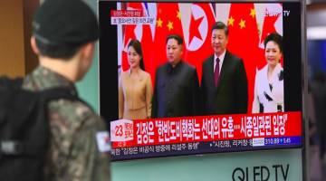 LAWATAN SULIT: Seorang askar Korea Selatan menonton berita televisyen mengenai lawatan sulit oleh pemimpin Korea Utara ke China, di stesen kereta api di Seoul semalam. — Gambar AFP 