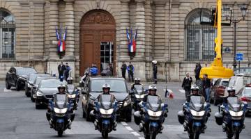 PERJALANAN TERAKHIR: Pengawal republikan mengiringi kereta membawa mayat Beltrame di Paris semalam. — Gambar AFP