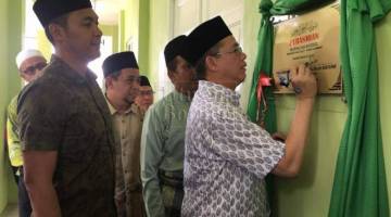 Fadillah menandatangani plak Surau As-Siddiq Taman Matang Ville - Taman Harmoni semasa majlis perasmian surau itu di Kuching hari ini. Turut kelihatan, Fazzruddin.