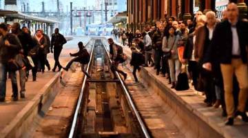 MANGSA MOGOK: Orang ramai menyeberangi landasan kereta api di sebuah stesen di Paris pada permulaan mogok selama                           tiga bulan yang dilancarkan oleh pekerja kereta api bermula semalam. — Gambar AFP 