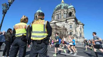 SERANGAN DIPINTAS: Anggota polis berkawal semasa acara separa maraton di Berlin, kelmarin. — Gambar AFP