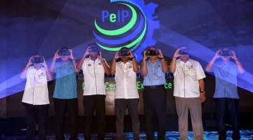 CANGGIH: Mohamed Khaled (tengah), Pengarah Urusan Serba Dinamik Holdings Berhad Datuk Dr Ir Mohd Abdul Karim Abdullah (tiga, kanan) dan Pengarah Urusan Perisind Samudera Sdn Bhd Datuk Mohd Shafiee Mohd Sanip (dua, kanan) menggunakan Virtual Reality Box (VR-Box) sebagai gimik Pecah Tanah Pengerang Eco Industrial Park (PeIP) di Pengerang semalam. — Gambar Bernama