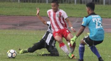 Nazarudin (tengah) cuba melepaskan diri dari kawalan pertahanan dan penjaga gol Terengganu FC III pada aksi Piala Presiden di Stadium Negeri, Petra Jaya hari ini.
