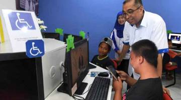 KEMUDAHAN: Salleh tertarik dengan kemudahan yang disediakan Pusat Internet 1Malaysia Kampung Tamau selepas merasmikannya di Kota Belud, semalam. — Gambar Bernama