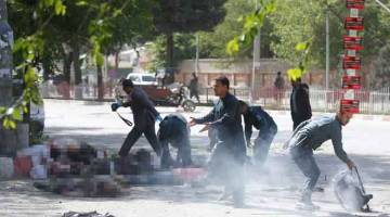TRAGIS: Anggota polis bergegas membantu wartawan dan mangsa letupan bom kedua di Kabul, Afghanistan semalam. — Gambar Reuters