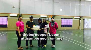 TAHNIAH: Iezuan menyampaikan hadiah kepada Kasuma dan Fazianah menjuarai edisi pertama Pertandingan Badminton ‘Double Knock Out’ Antara Beregu Wanita Jemputan KSRJPS 2018 kelmarin.