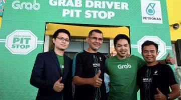 USAHA SAMA: Syed Zainal (dua kiri) bergambar bersama (dari kiri) Sean dan Aadrin selepas melancarkan ‘Grab Driver Pit Stop’ di stesen Petronas Mutiara Damansara, Kuala Lumpur, semalam. — Gambar Bernama