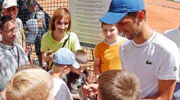 BERSEMANGAT: Djokovic menurunkan tandatangan untuk peminatnya ketika sesi latihan di Belgrade, Serbia. — Gambar AFP