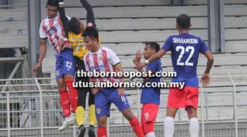 TANGKAP: Penjaga gol ATM, Mohd Hafizuddin berjaya menangkap bola sebelum disambar pemain pertahanan Kuching FA, Sahran Abdul Samad pada perlawanan Piala FAM di Kuching semalam.