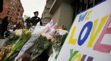 TRAGIS: Gambar fail 26 Oktober, 2012 menunjukkan bunga dan pesanan ditinggalkan di hadapan bangunan di mana dua                      kanak-kanak ditikam hingga mati oleh pengasuh mereka di apartmen Upper West Side di New York. — Gambar AFP