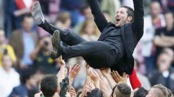 DETIK BERSEJARAH: Simeone dijulang oleh para pemain ketika meraikan kejayaan Atletico menjuarai kejuaraan La Liga Sepanyol selepas perlawanan menentang Barca di Nou Camp, Barcelona dalam gambar fail bertarikh 17 Mei 2014. — Gambar Reuters