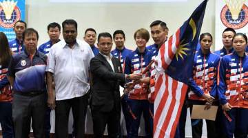 YAKIN BOLEH: Norza menyerahkan bendera kepada Chong Wei pada program memperkenalkan Skuad Malaysia bagi Piala Thomas dan Piala Uber di Kuala Lumpur semalam. — Gambar Bernama