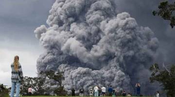 LETUSAN ABU: Orang ramai berkumpul di padang golf untuk menyaksikan dari jauh kepulan abu yang meletus dari gunung berapi Kilauea di Big Island, Hawaii kelmarin. — Gambar AFP