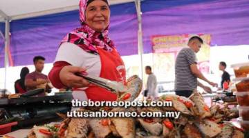 LAZAT: Hanipah menunjukkan ikan terubok goreng yang terdapat digerai jualannya.