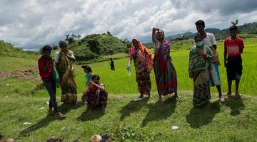 JENAYAH KEJAM: Gambar fail 27 September menunjukkan wanita dan lelaki Hindu meratap berhampiran mayat ahli keluarga              mereka di kampung Ye Baw Kyaw, Maungdaw di negeri utara Rakhine di Myanmar. — Gambar AFP 