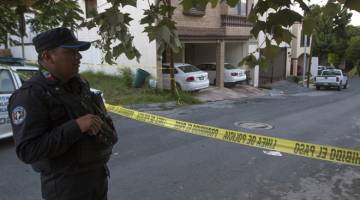 SIASAT: Seorang anggota polis berkawal di luar rumah Alicia Diaz Gonzalez di Monterrey, Mexico. — Gambar AFP