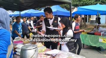 PATUHI PERATURAN: Pemeriksaan di salah sebuah gerai di Bazar Ramadan Majlis Daerah Kota Belud oleh anggota penguatk uasa Unit Keselamatan dan Kualiti Makanan PKD Kota Belud.