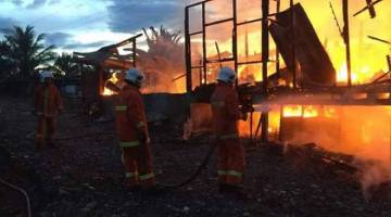 BOMBA sedang bertungkus lumus memadamkan api.