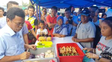 SHAFIE meninjau juadah yang dijual oleh salah seorang peniaga di bazar Ramadan Sembulan.