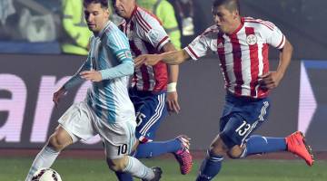 LICIK: Messi (kiri)diasak oleh dua pemain  Paraguay ketika beraksi pada perlawanan COpa Amerika di Concepcion, Chile dalam gambar fail 30 Jun 2015.   — Gambar AFP 