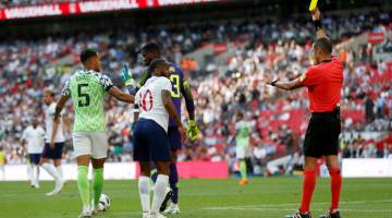 MINGGU SUKAR: Sterling (tengah) dilayangkan kad kuning kerana sengaja menjatuhkan diri dalam kotak penalti pada perlawanan di Wembley, London Sabtu lepas. — Gambar AFP