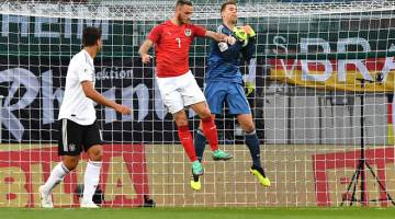 AKSI TANGKAS: Neuer (kiri) mengatasi Arnautovic untuk mendapatkan bola ketika beraksi pada perlawanan persahabatan antarabangsa di Stadium Worthersee, Austria pada Sabtu lepas. — Gambar AFP