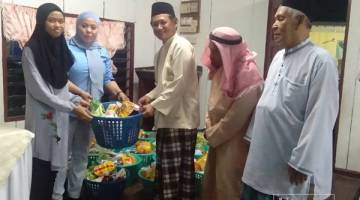 AWANG Husaini (tiga kanan) menyampaikan raga makanan sumbangan Yayasan Afat Rahman kepada salah seorang penerima.