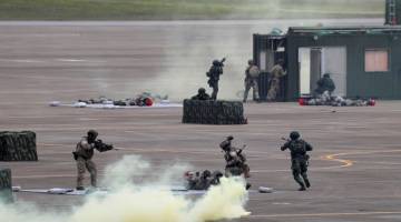 SIAP SIAGA: Anggota tentera mengambil bahagian dalam latihan ketenteraan Han Kuang mensimulasikan Tentera Pembebasan Rakyat China (PLA) menceroboh pulau itu di Pangkalan Udara Ching Chuan Kang di Taichung, Taiwan semalam. — Gambar Reuters