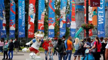 COMEL: Orang ramai tertarik melihat maskot Piala Dunia 2018, Zabivaka yang di letakkan di laluan utama di Stadium Saint Petersburg, Rusia  kelmarin. — Gambar Reuters