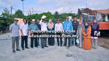 IKUT JADUAL: Arunarnsin (enam kanan) dan Ruji (lima kiri) bergambar bersama wakil Jabatan Pendidikan Negeri, pihak sekolah dan kontraktor selepas lawatan ke projek sekolah daif di SK Batu 16 Gum-Gum, Libaran. 