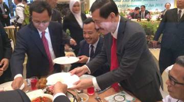 SHAFIE membantu mengambil makanan untuk Setiausaha Tetap Kementerian Kewangan Datuk Pg Hassanel Pg Hj Mohd Tahir, sempena jamuan selepas perjumpaan bersama kakitangan kerajaan negeri dan Persekutuan hari ini.