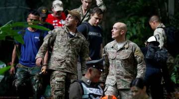 SEDIA BEKERJASAMA: Anggota tentera AS keluar dari gua Tham Luang ketika menyertai usaha menyelamat 12 kanak-kanak bersama jurulatih mereka yang terperangkap di dalam gua tersebut di wilayah Chiang Rai, Thailand semalam. — Gambar Reuters	