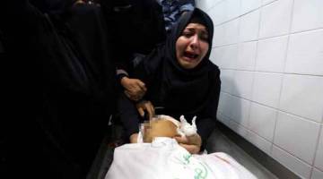 PILU: Ahli saudara remaja lelaki Palestin berusia 14 tahun Yasser Abu Al-Naja meratapi jenazahnya di rumah mayat hospital. — Gambar Reuters 