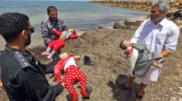 TRAGIS: Anggota pasukan keselamatan Libya dan orang awam membawa mayat bayi manakala pendatang yang terselamat dalam kejadian bot getah karam di perairan pantai Libya dibawa ke darat di Al-Hmidiya, ke timur ibu negara Tripoli kelmarin. — Gambar AFP