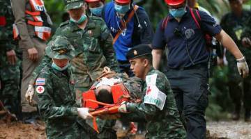 MISI SUKAR: Askar dan penyelamat membawa keluar mangsa simulasi (olok-olok) sewaktu latihan, dekat kompleks gua Tham Luang, manakala operasi mencari diteruskan bagi sebuah pasukan bola sepak bawah 16 dan jurulatih mereka di Thailand semalam. — Gambar Reuters