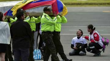 SEBAK: Sanak saudara dan sahabat handai pasangan suami isteri yang diculik menyambut ketibaan mayat di Lapangan Terbang Mariscal Surce di Ecuador. — Gambar AFP