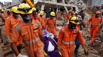 MALANG: Anggota penyelamat mengangkat mayat mangsa dari tapak sebuah bangunan yang roboh di kampung Shah Beri di Greater Noida kelmarin. — Gambar Reuters