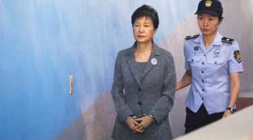 HUKUMAN DITAMBAH: Gambar fail 25 Ogos, 2017 menunjukkan Park (kiri) diiringi oleh pengawal penjara wanita tiba di mahkamah di Seoul. — Gambar Reuters