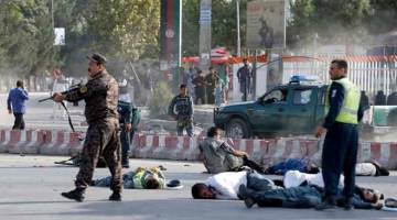 AKIBAT BOM NEKAD: Beberapa mangsa kelihatan terbaring di atas jalan raya selepas letupan bom di Kabul kelmarin. — Gambar Reuters